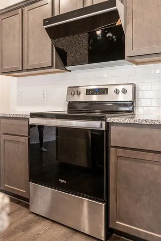 a stove top oven sitting inside of a kitchen