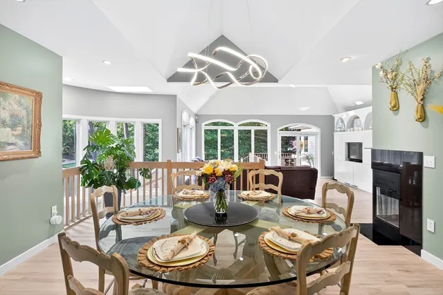 a large white kitchen with stainless steel appliances wooden floor and a large window