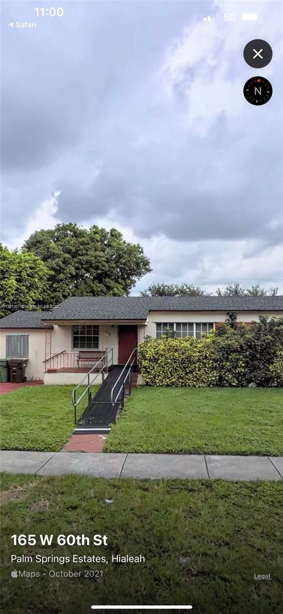 a view of a big yard with a house in the background