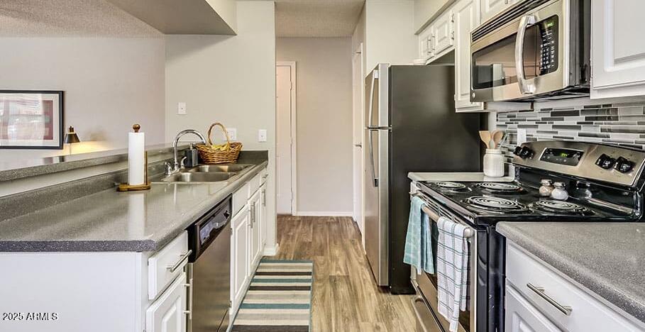 445 South Dobson Road, Unit A1 Mesa, AZ 85202 - Photo 2 of 7 a kitchen with stainless steel appliances granite countertop a stove and a refrigerator