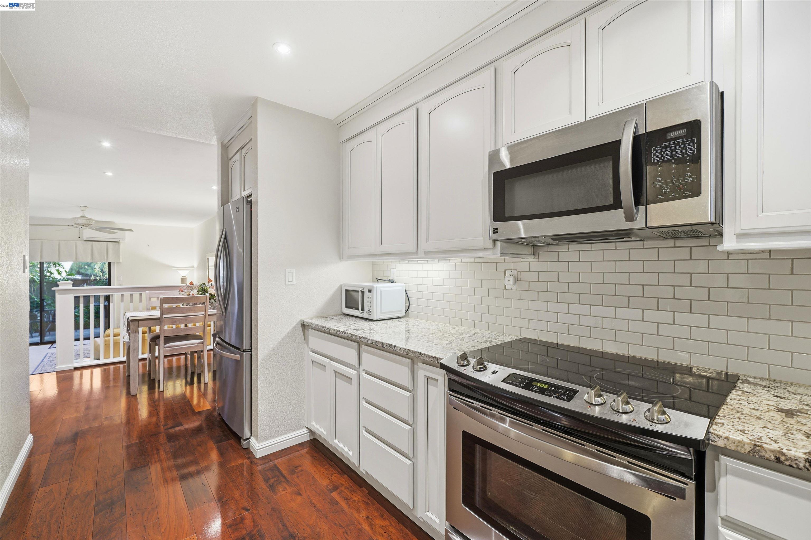 8985 Alcosta Boulevard, Unit 162 San Ramon, CA 94583 - Photo 15 of 33 a kitchen with a stove a microwave and wooden floor