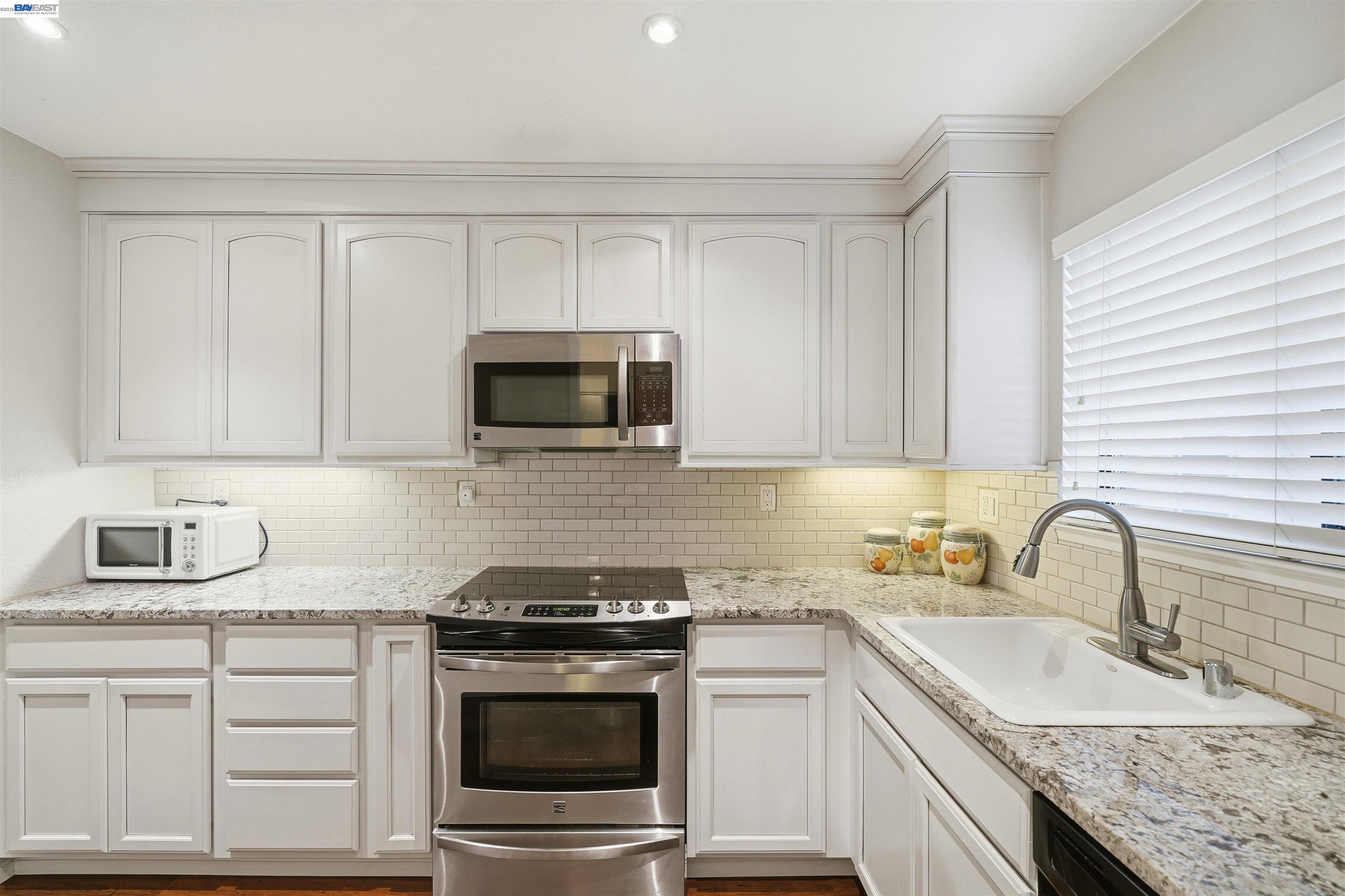 8985 Alcosta Boulevard, Unit 162 San Ramon, CA 94583 - Photo 16 of 33 a kitchen with granite countertop white cabinets sink and stainless steel appliances