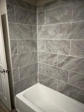 a room with wooden floor and white cabinets