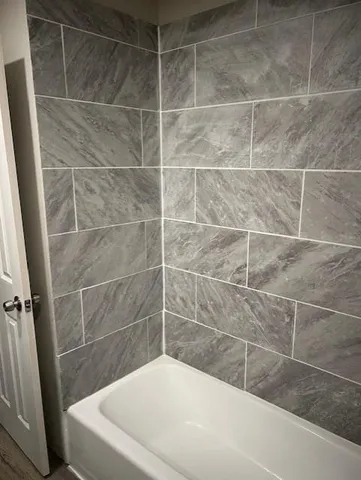 a room with wooden floor and white cabinets