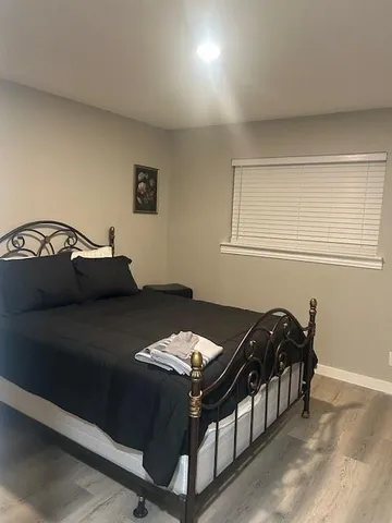 a bed sitting in a bedroom next to a window