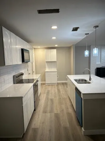 a kitchen with kitchen island a sink stainless steel appliances and cabinets