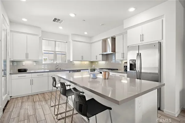 a kitchen with a sink a center island cabinets and stainless steel appliances