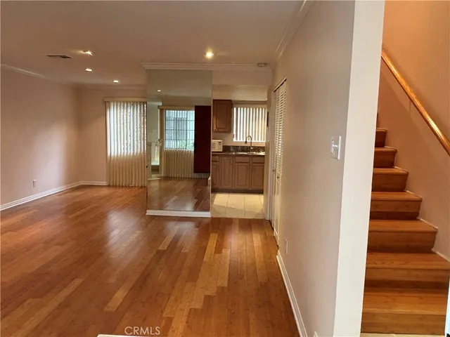 a view of a hallway with wooden floor fireplace and living room