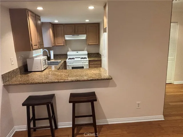 a kitchen with stainless steel appliances granite countertop a stove a sink and a microwave