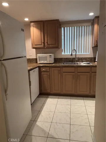 a kitchen with stainless steel appliances granite countertop a refrigerator and a sink