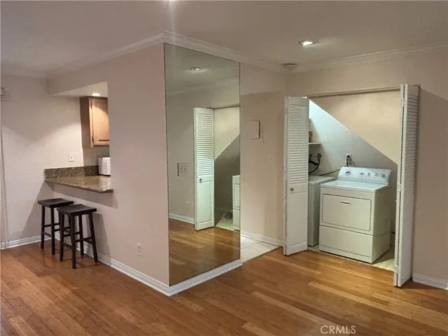 a view of a room with wooden floor cabinet and a bathroom