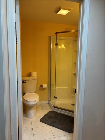 a bathroom with a granite countertop toilet and a shower