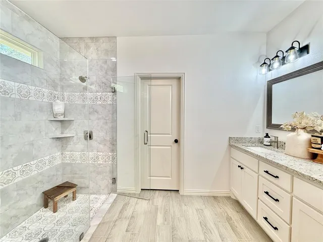 a bathroom with a double vanity sink mirror and shower
