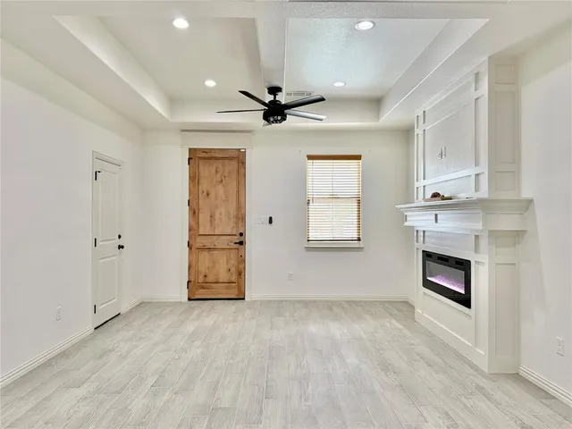 an empty room with windows and fireplace