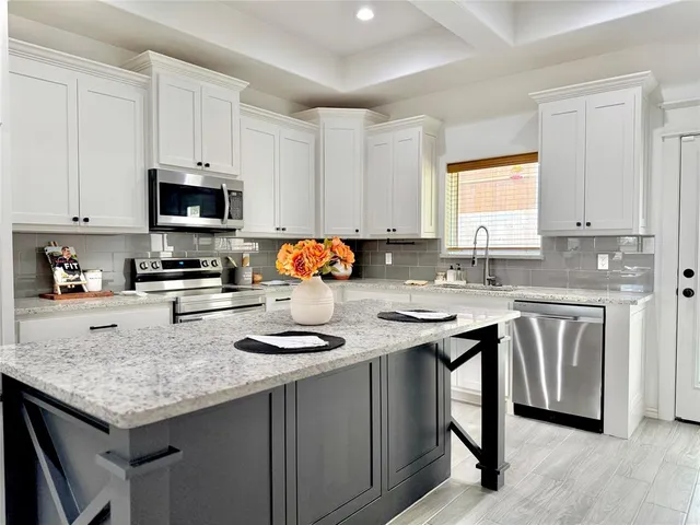 a kitchen with granite countertop a sink stove and cabinets