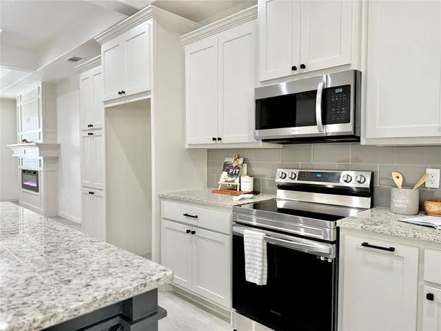 a kitchen with stainless steel appliances a stove microwave and sink
