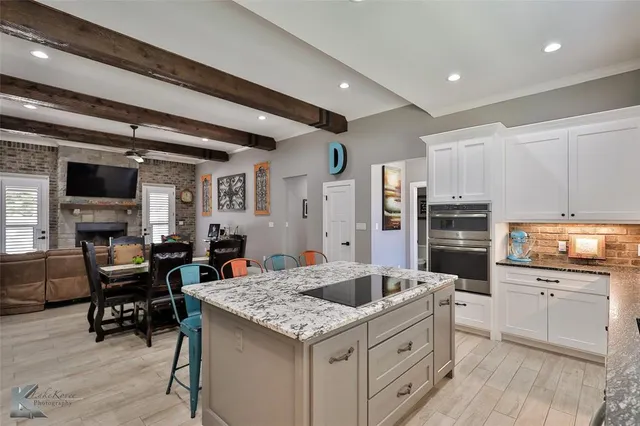 a kitchen with stainless steel appliances kitchen island granite countertop a sink and cabinets