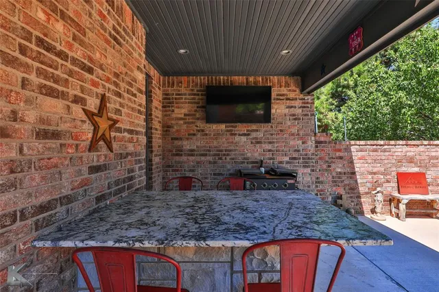 a view of a patio with a table chairs and a wooden deck