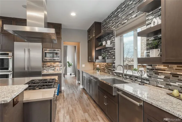 a kitchen with stainless steel appliances granite countertop a sink stove and refrigerator