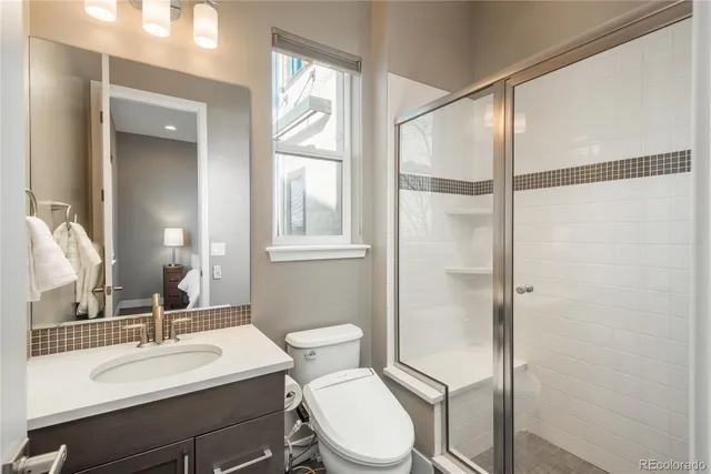 a bathroom with a sink vanity mirror and toilet