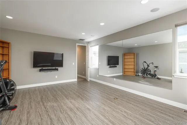a view of a livingroom with a flat screen tv wooden floor and a window
