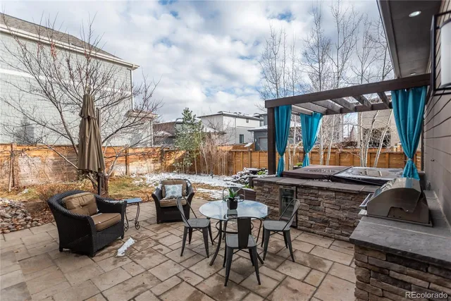 a backyard of a house with barbeque oven table and chairs