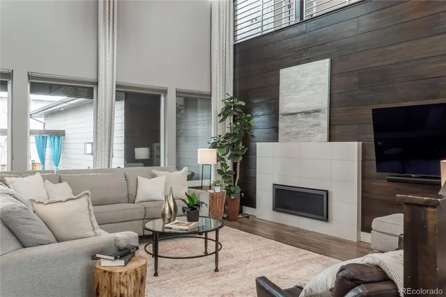 a living room with furniture a flat screen tv and a fireplace