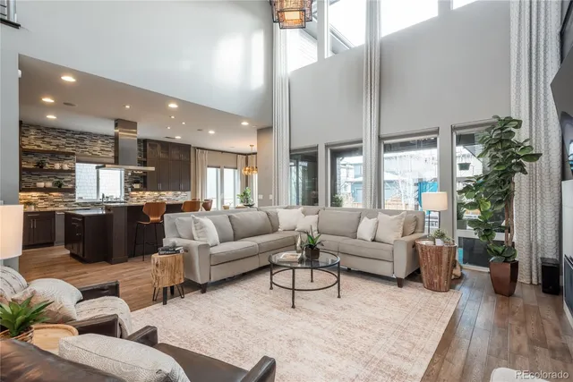 a living room with furniture kitchen and a large window