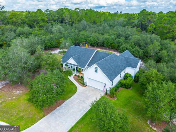 an aerial view of a house with yard and green space