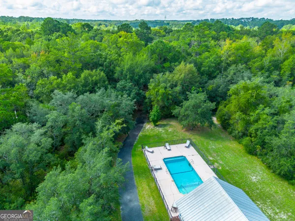 a view of a house with pool and a yard