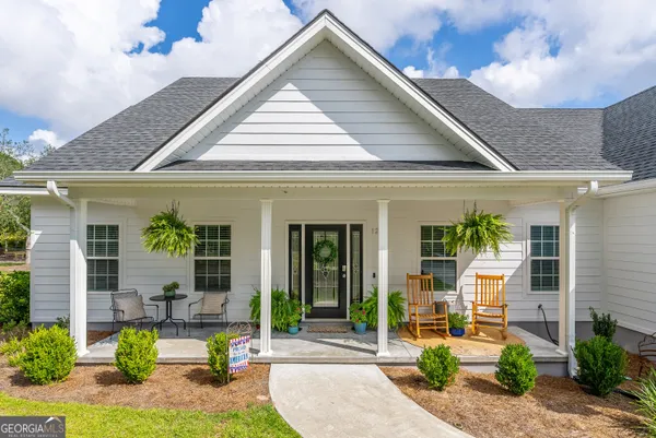 a front view of a house with garden and plants