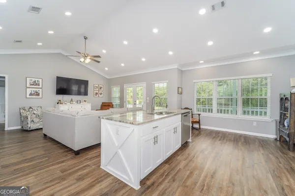 a kitchen with granite countertop a stove top oven microwave and refrigerator