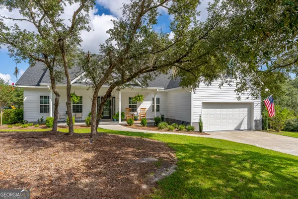 a view of a house with a yard and tree s