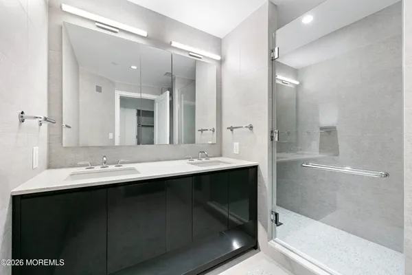 a white bath tub sitting next to a white sink and a shower