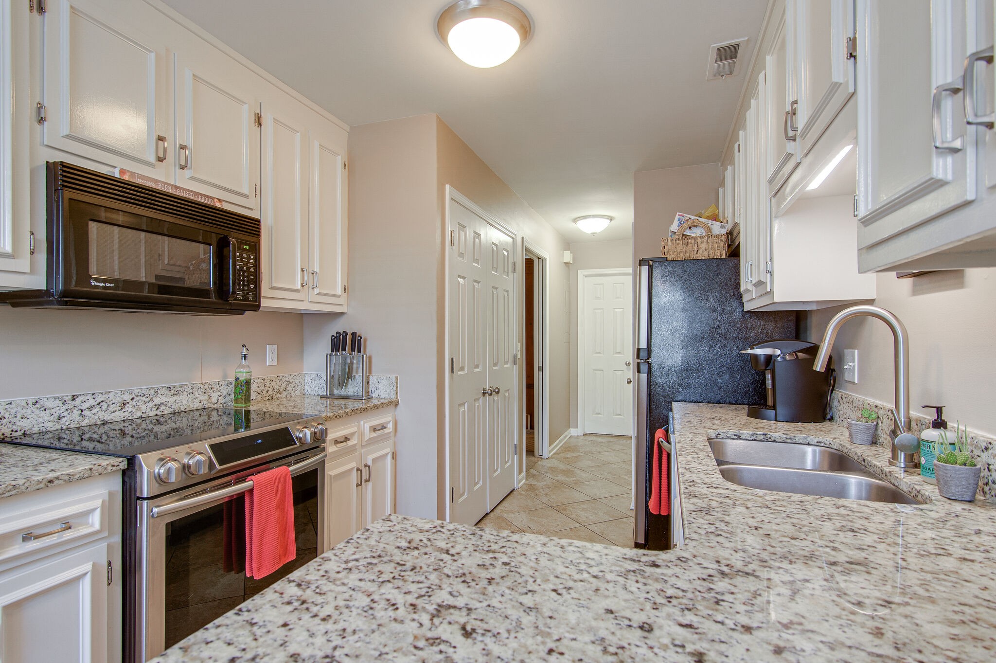 902 General George Patton Road Nashville, TN 37221 - Photo 9 of 22 a kitchen with stainless steel appliances granite countertop a sink stove and cabinets