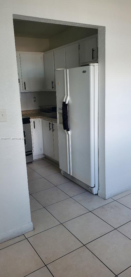 5702 West 26th Avenue, Unit 5702 Hialeah, FL 33016 - Photo 1 of 10 a kitchen with a refrigerator and white cabinets