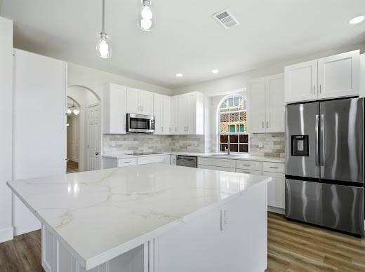 5034 West Fall Drive Midlothian, TX 76065 - Photo 17 of 40 Expansive kitchen island with a light-toned countertop, complemented by white cabinetry and stainless steel appliances