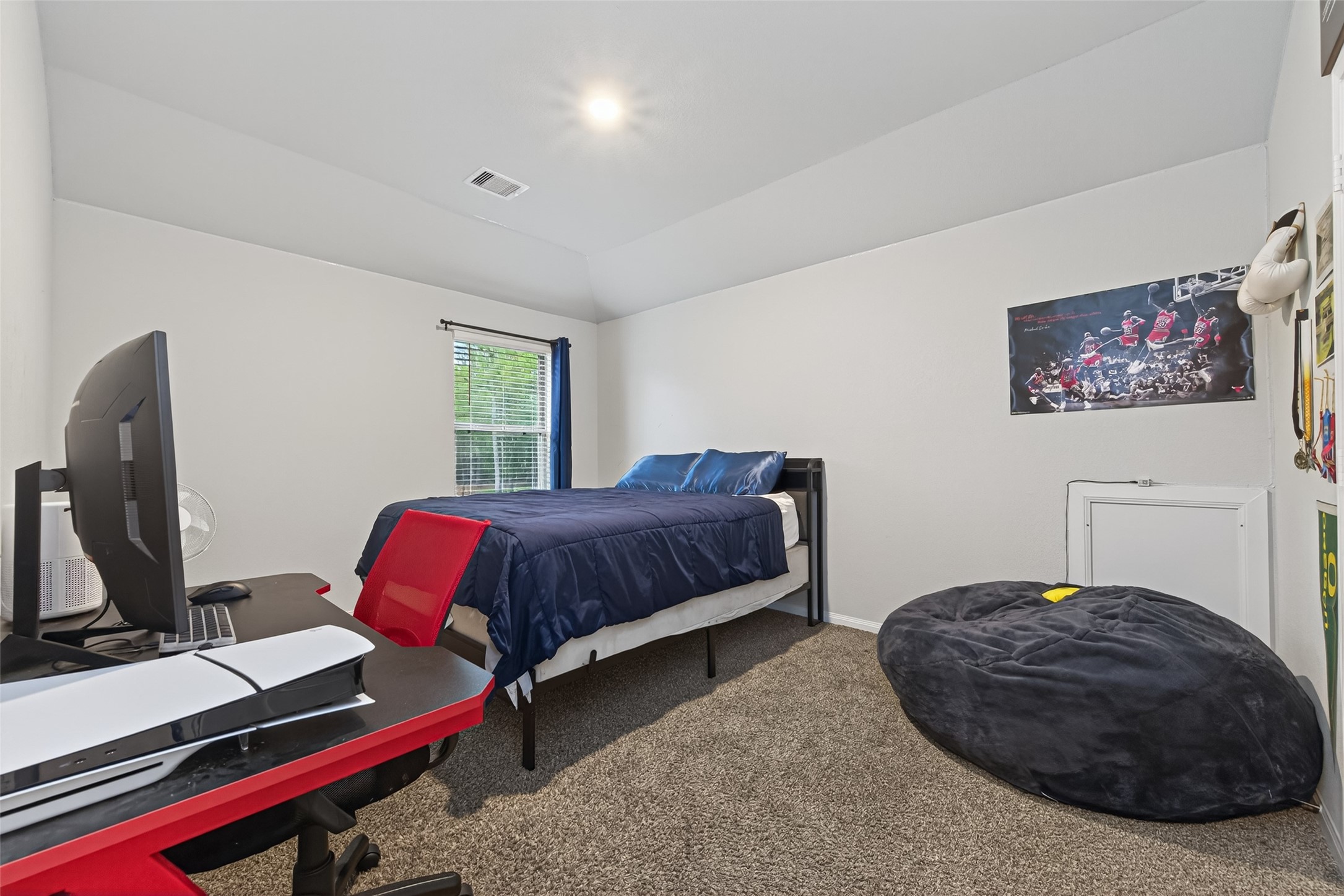 16601 Crosby Street Conroe, TX 77303 - Photo 33 of 50 Comfortable secondary bedroom with vaulted ceilings, soft carpeting, and a large window that fills the space with natural light.