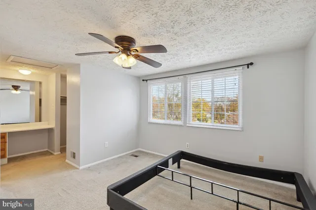 a room with chandelier fan and windows