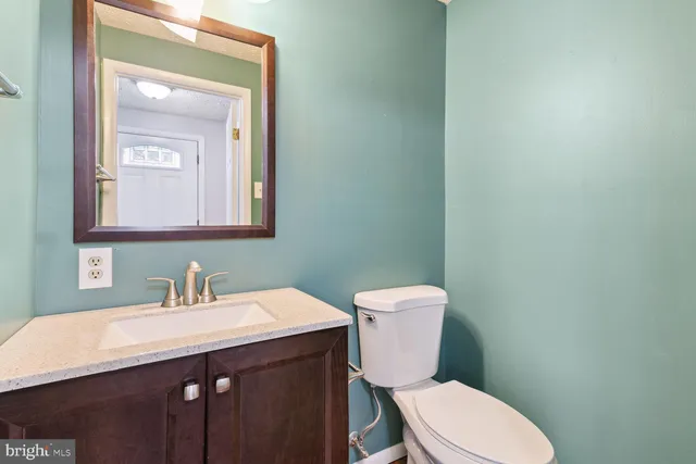 a bathroom with a toilet a sink and mirror