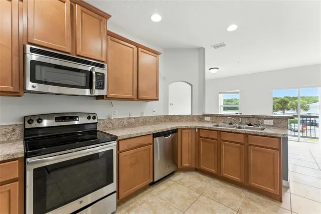 a kitchen with stainless steel appliances granite countertop a stove microwave and sink