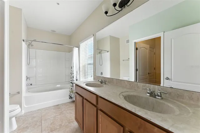 a bathroom with a granite countertop tub sink and mirror
