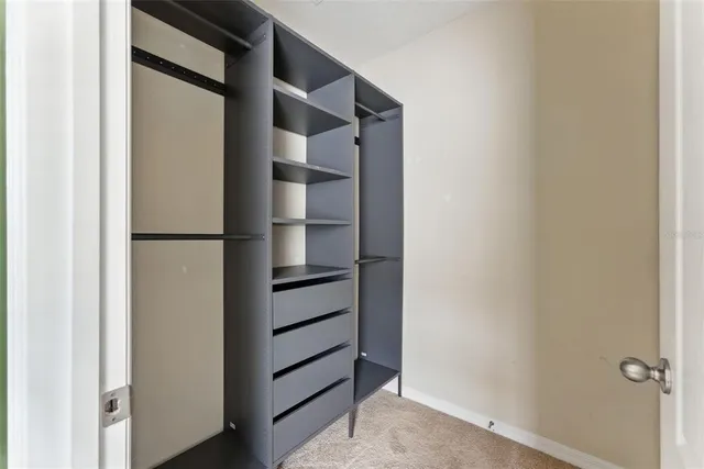 a view of walk in closet with empty racks