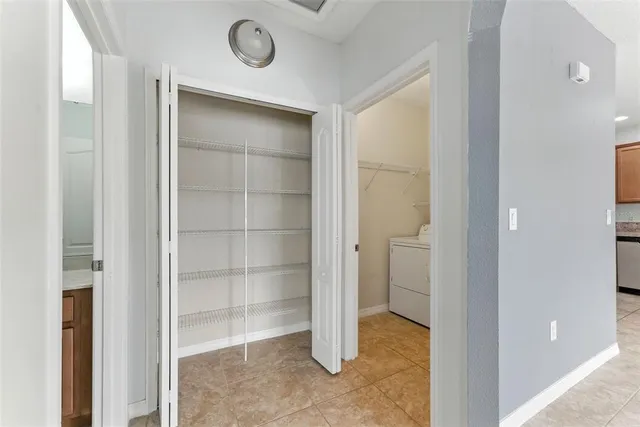 a view of an empty room with cabinet and a bathroom