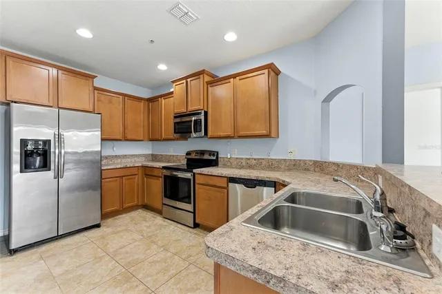 a kitchen that has a sink cabinets counter space stainless steel appliances