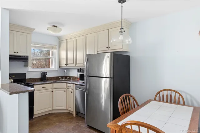 a kitchen with stainless steel appliances granite countertop a sink a refrigerator and a stove