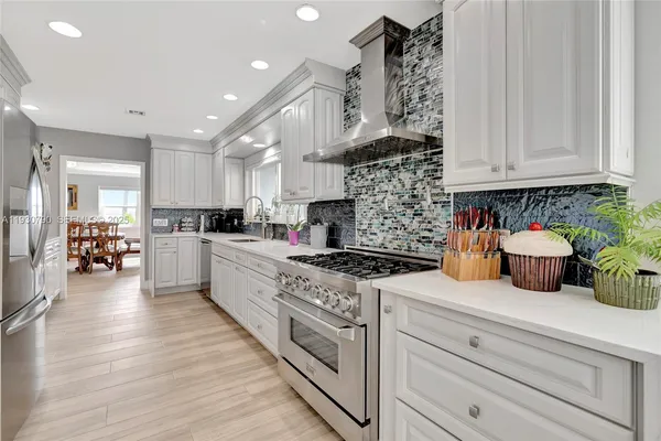a kitchen with stove a refrigerator and cabinets