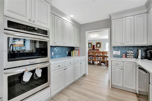 a kitchen with white cabinets and black appliances
