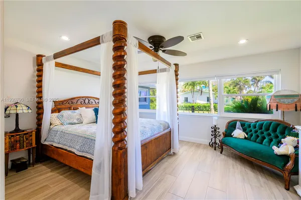 a bedroom with furniture and a large window