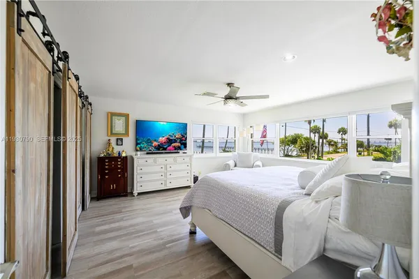a living room with a bed furniture and a flat screen tv